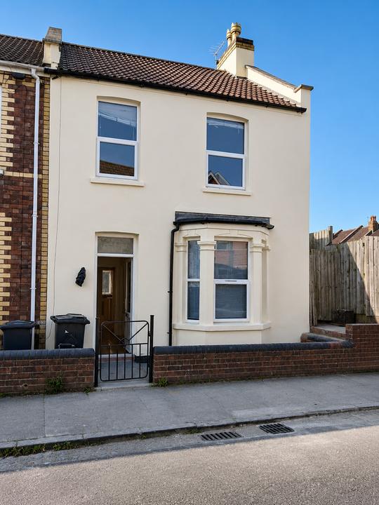 Rendered end-of-terrace house with stone quoins